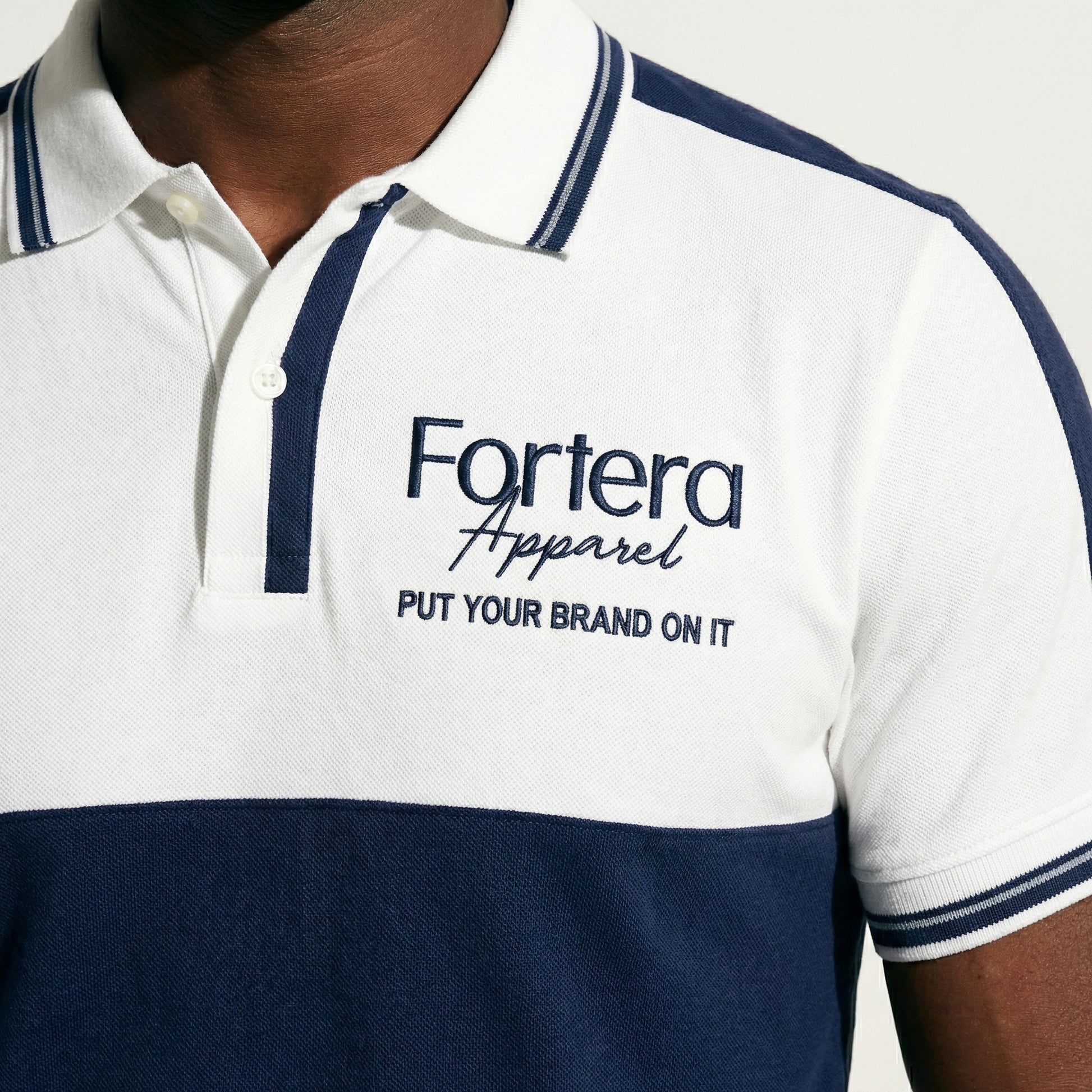 White and navy bulk embroidered polo shirt with bold color block design - male fit