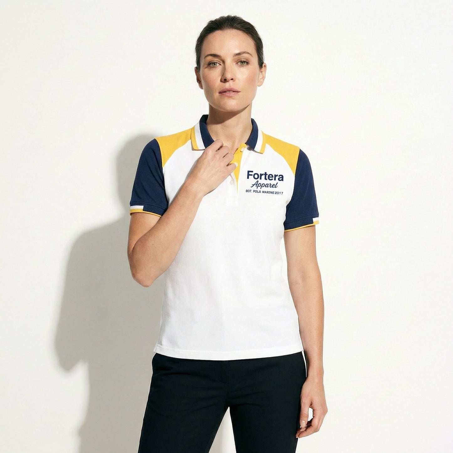 White bulk embroidered polo shirt with navy and yellow shoulder block - detail close-up