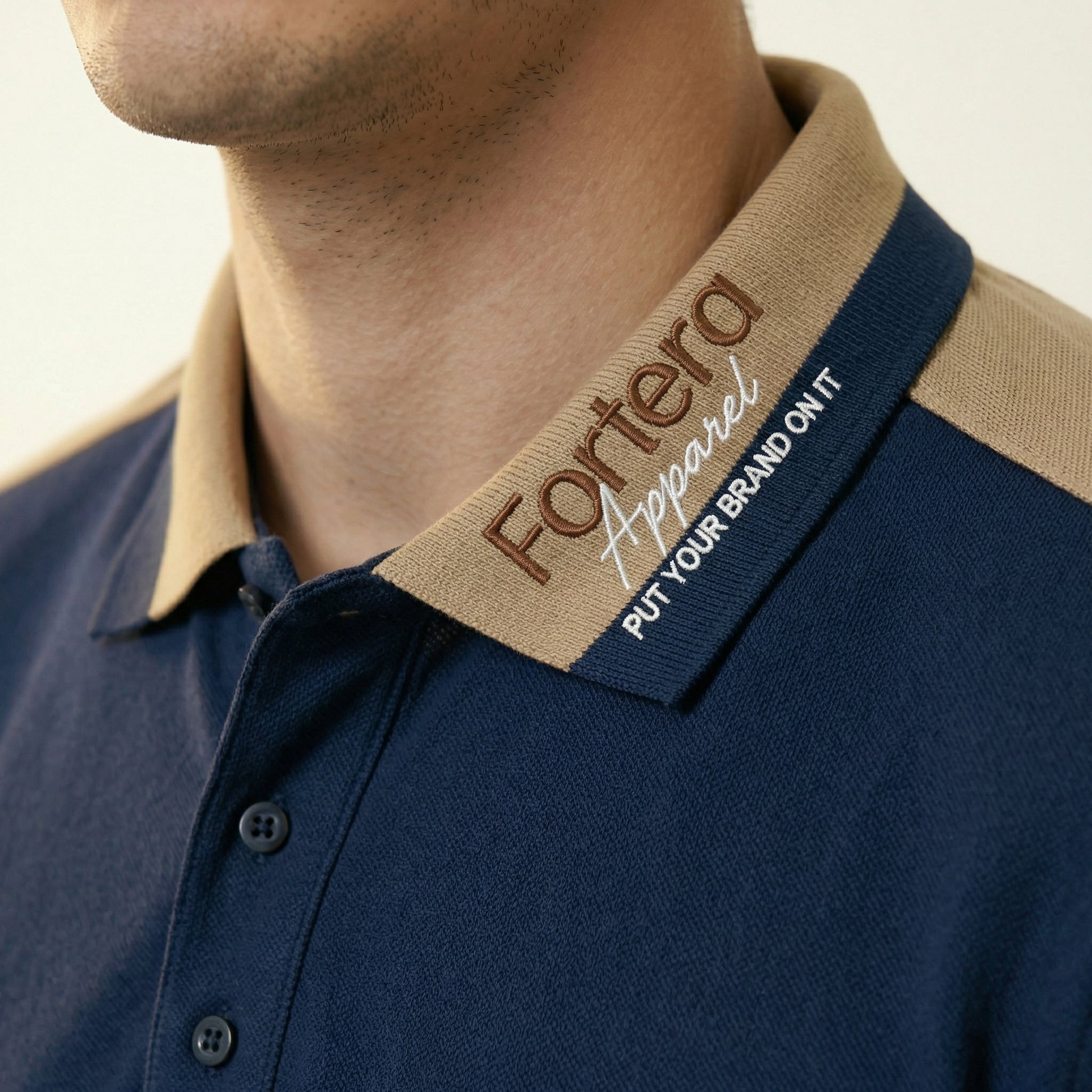 Navy bulk embroidered polo shirt with tan gold shoulder panel detail - logo embroidery detail