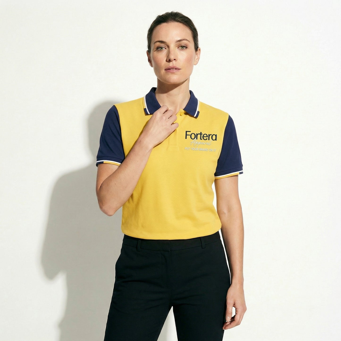 Yellow custom business polo shirt with navy shoulder panel and embroidered logo - detail close-up