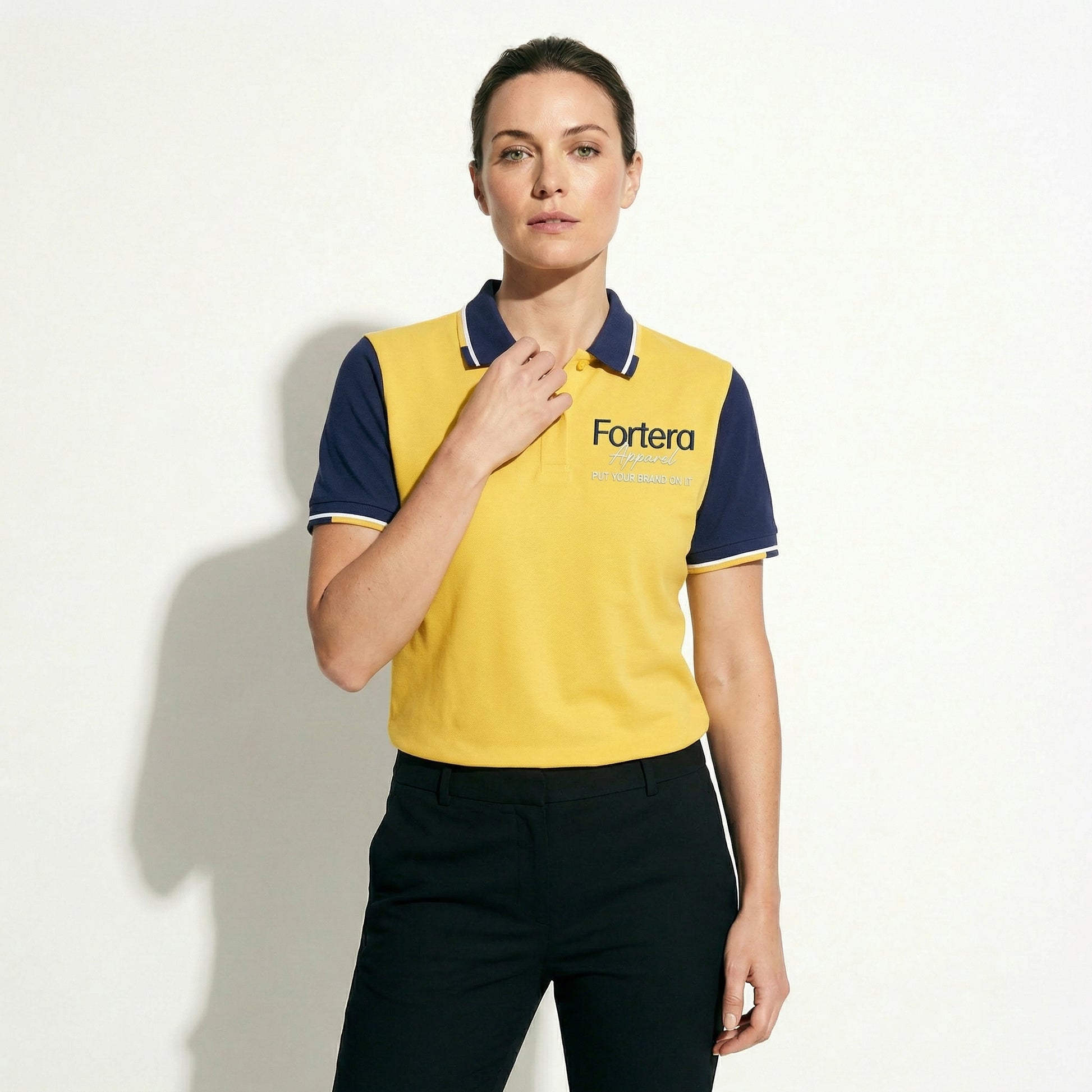 Yellow custom business polo shirt with navy shoulder panel and embroidered logo - detail close-up
