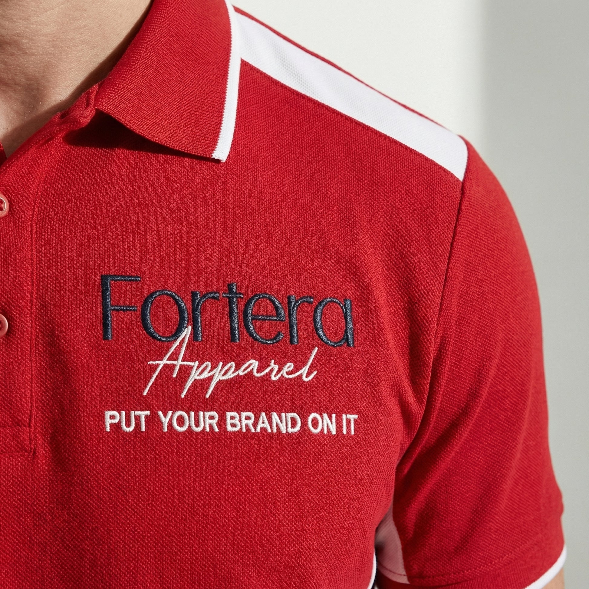 Red custom polo shirt with logo and white angular panel accent - male fit