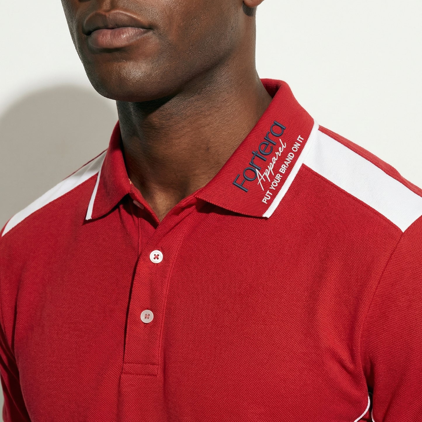 Red custom polo shirt with logo and white angular panel accent - logo embroidery detail