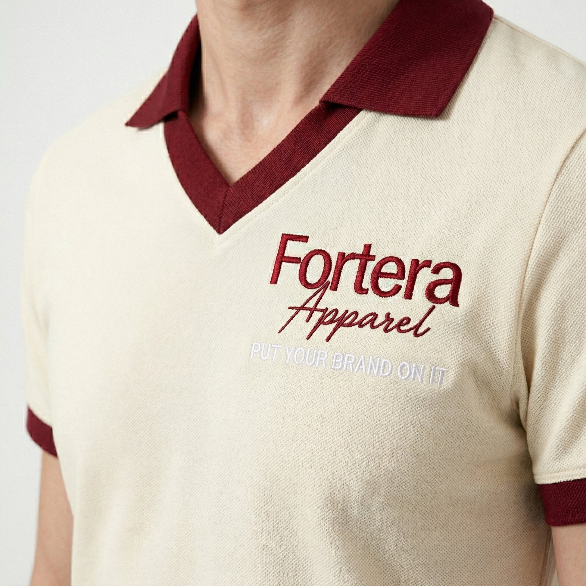Cream custom staff polo shirt with burgundy heart collar V-neck accent - male fit