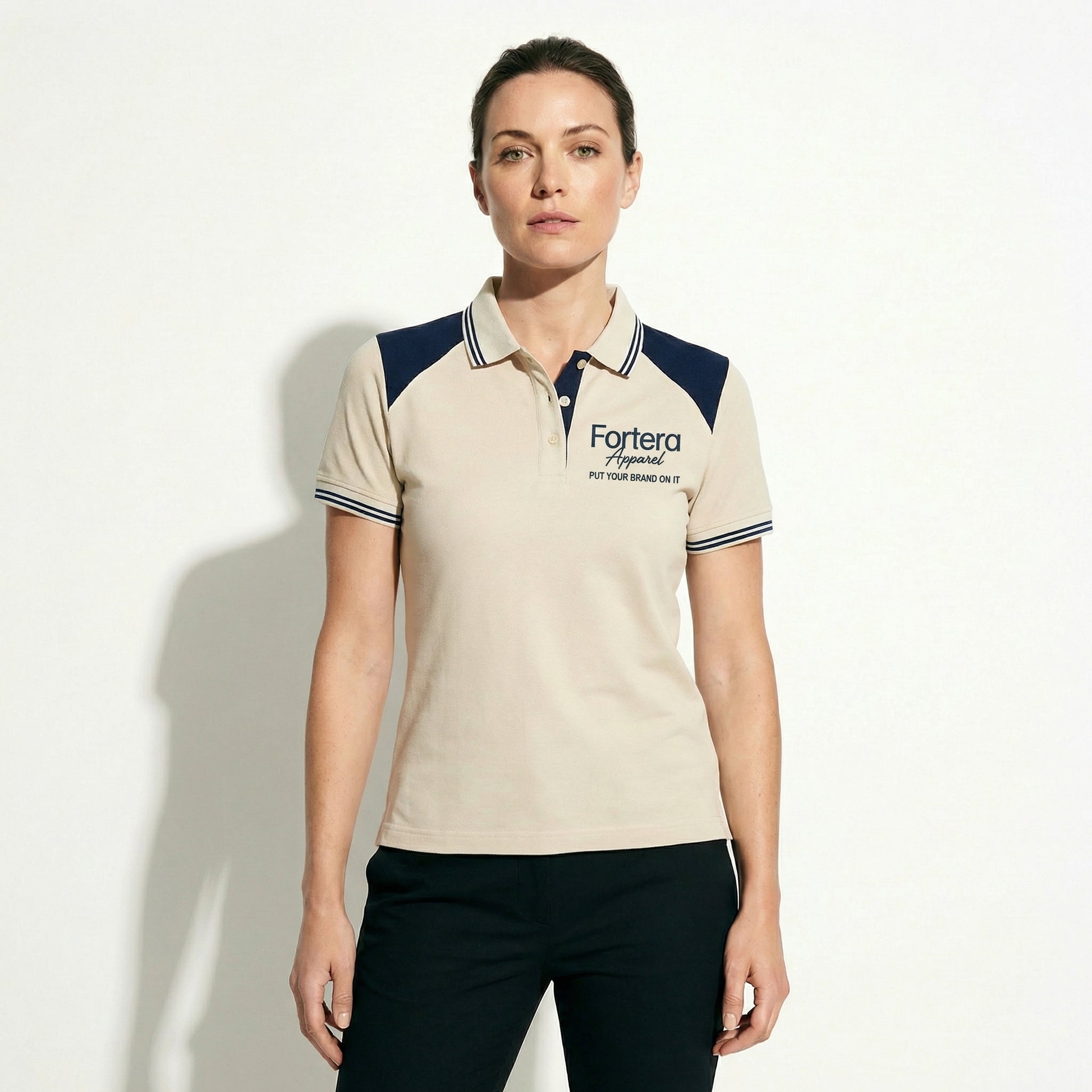 Beige embroidered polo shirt with navy yoke panel across shoulders - detail close-up