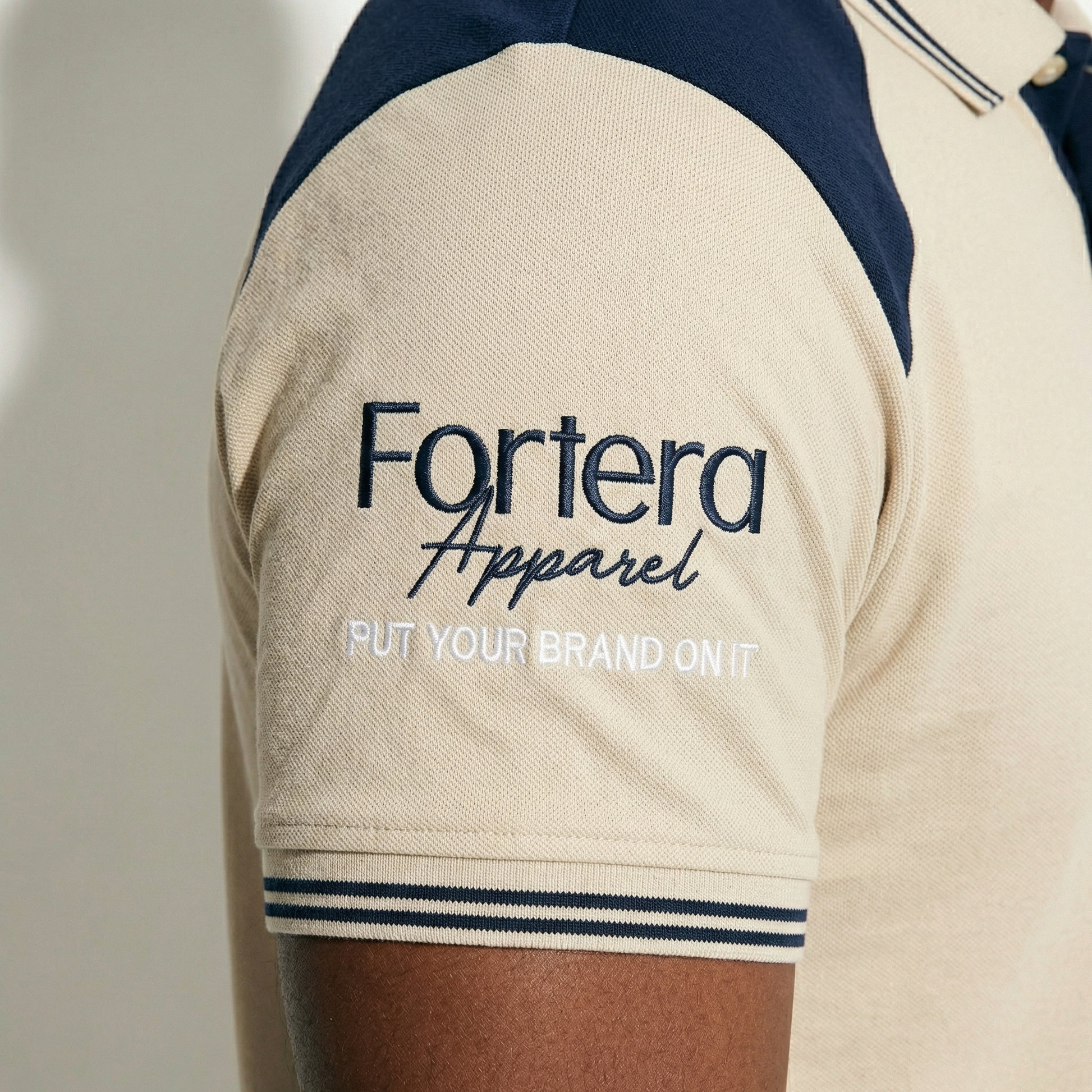 Beige embroidered polo shirt with navy yoke panel across shoulders - team uniform group