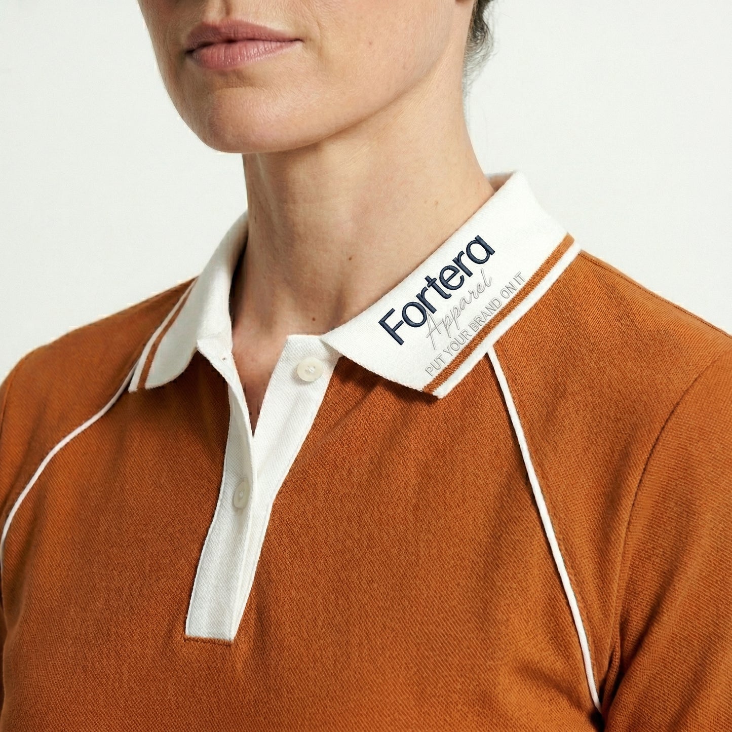 Orange moisture wicking polo uniform with white piping detail on collar and chest - logo embroidery detail