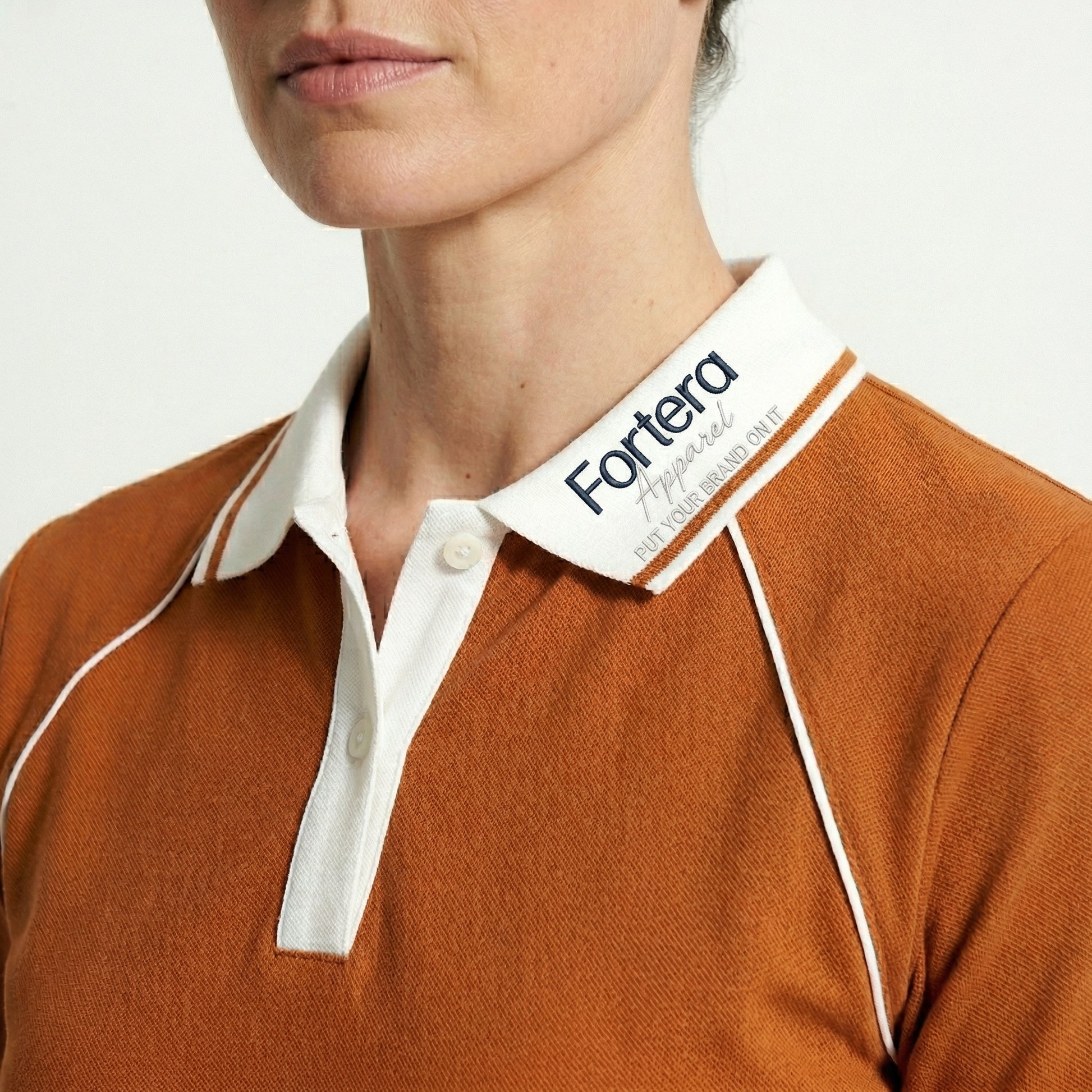 Orange moisture wicking polo uniform with white piping detail on collar and chest - logo embroidery detail