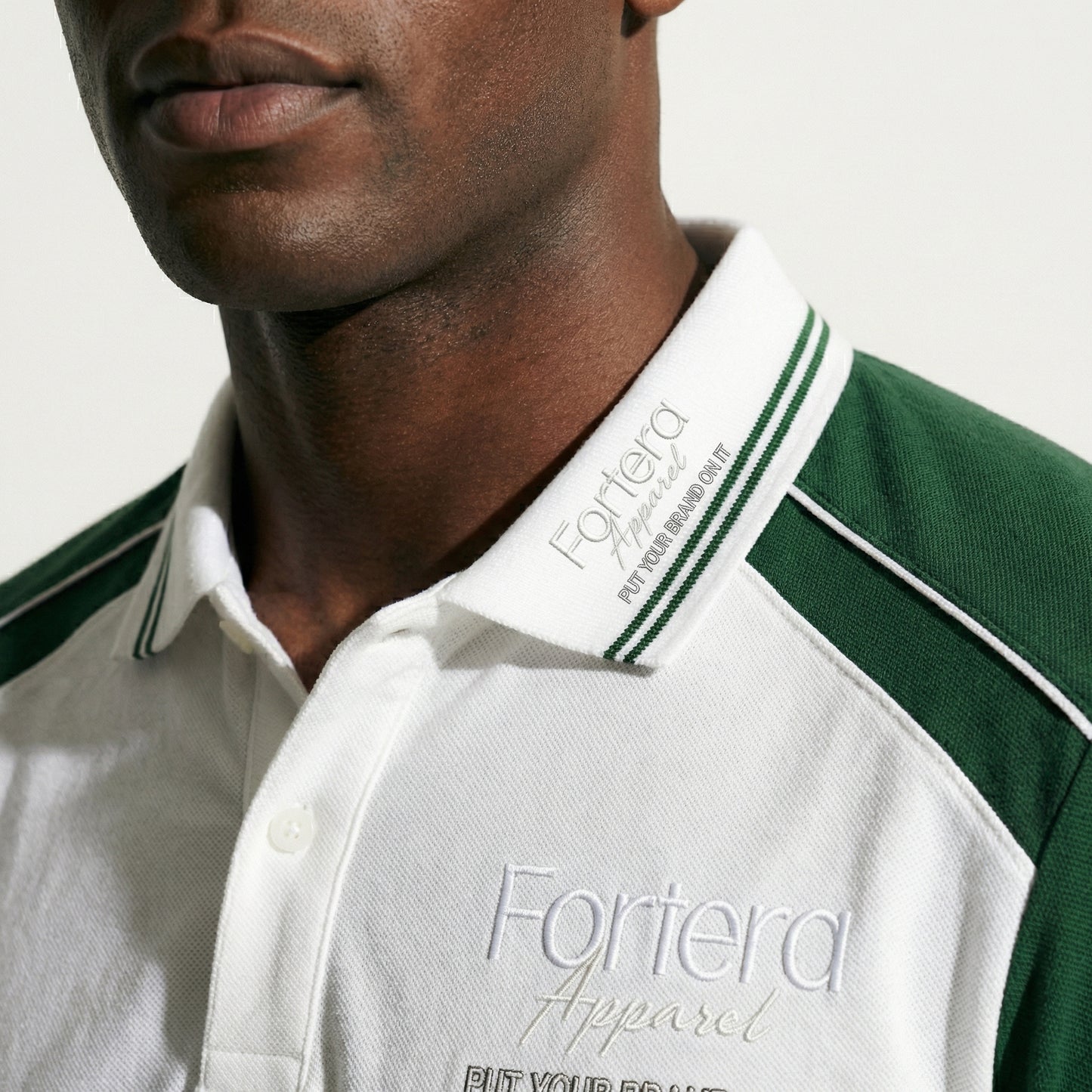 White moisture wicking polo uniform with forest green two-tone shoulder panel - team uniform group