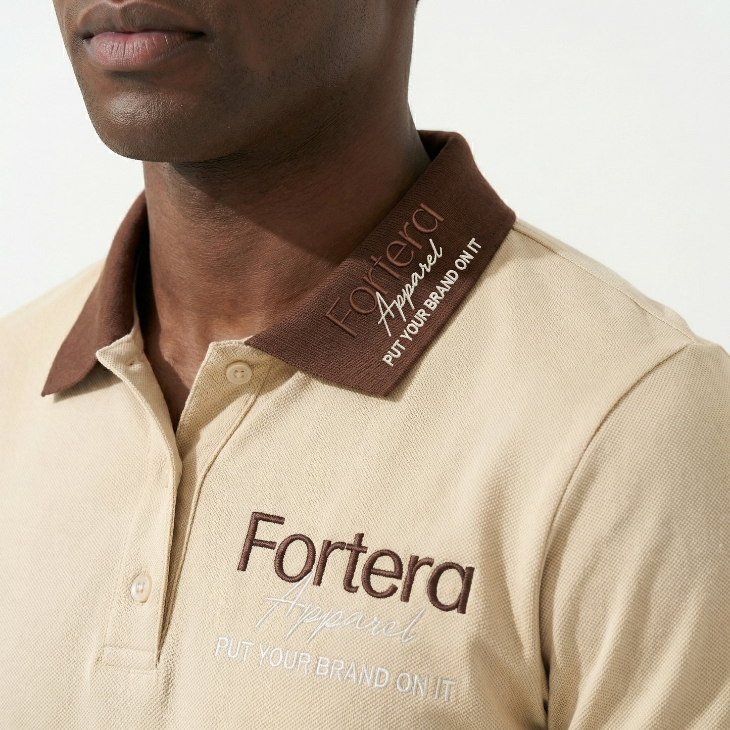 Beige polo shirt with company logo and dark brown contrast tipping on collar and cuffs - logo embroidery detail