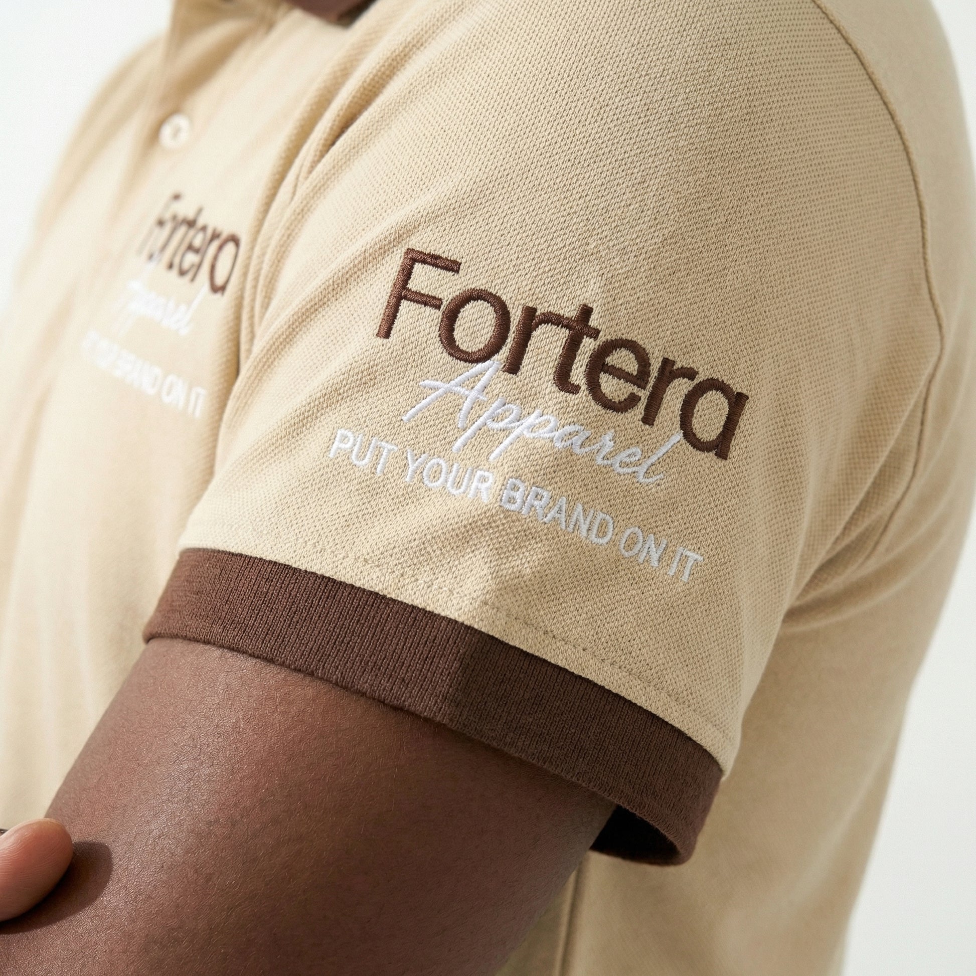 Beige polo shirt with company logo and dark brown contrast tipping on collar and cuffs - team uniform group