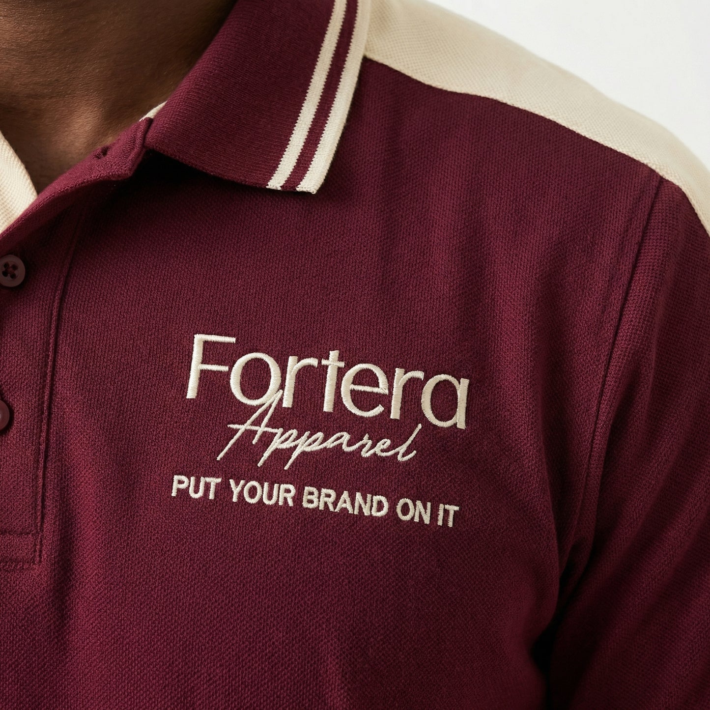 Burgundy polo shirt with company logo and cream shoulder panel accent - male fit