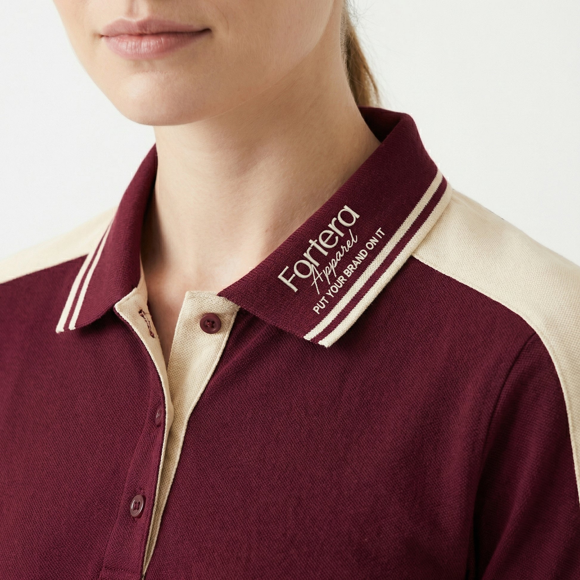 Burgundy polo shirt with company logo and cream shoulder panel accent - logo embroidery detail