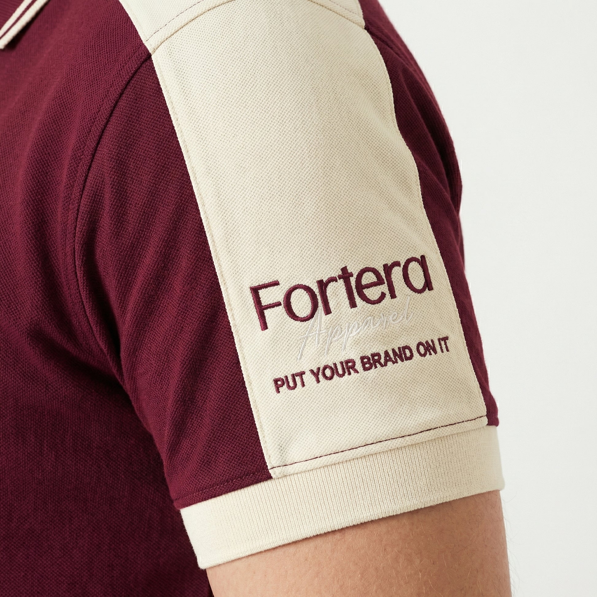 Burgundy polo shirt with company logo and cream shoulder panel accent - team uniform group