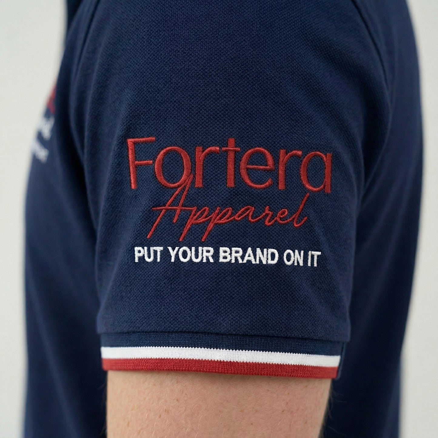 Navy polo shirt with embroidered logo and red white stripe tipping on collar - team uniform group
